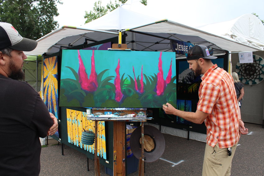 Golden-based acrylic painter Jesse Crock, right, does a painting demonstration during the Golden Fine Arts Festival Aug. 20 in downtown Golden.